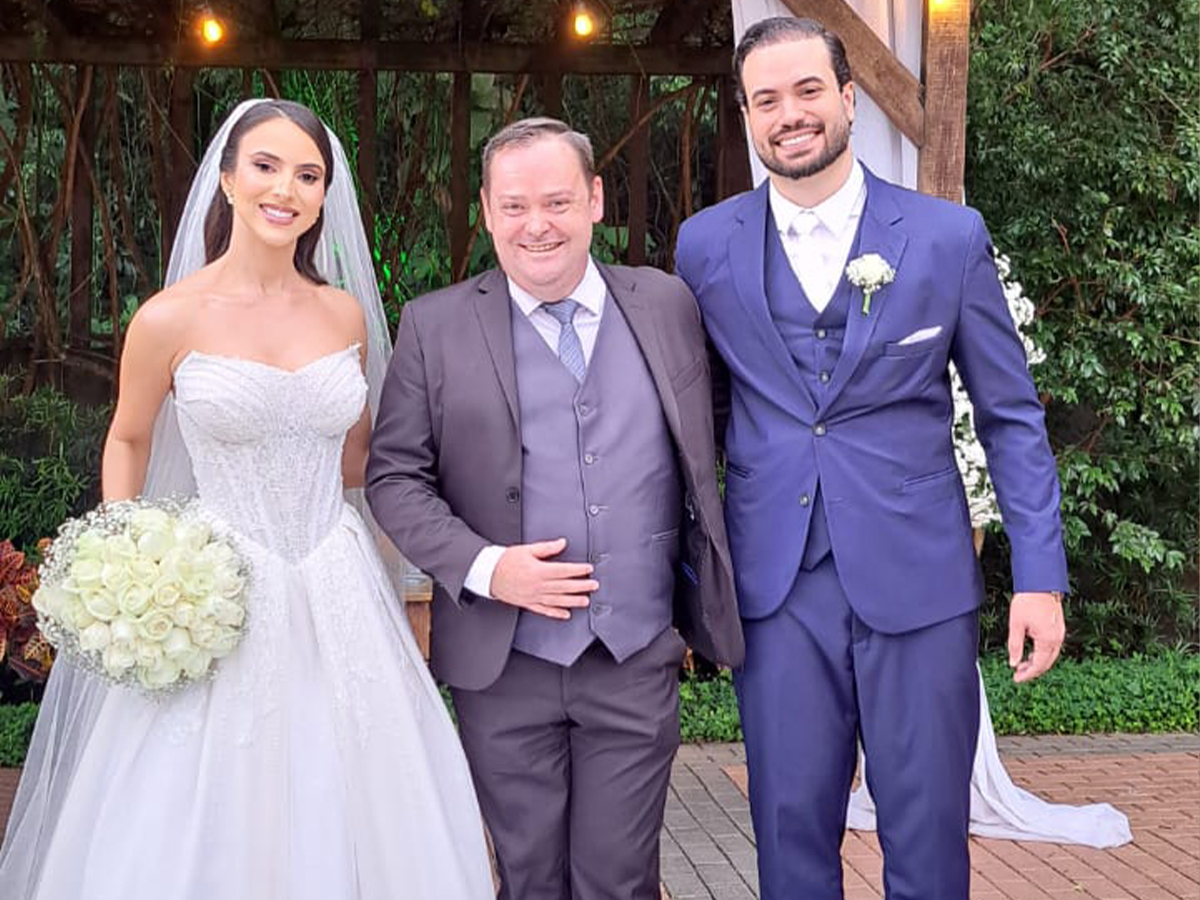 Celebrante de casamento Camilo Lelles com noivos em cerimônia ao ar livre sob pérgola
