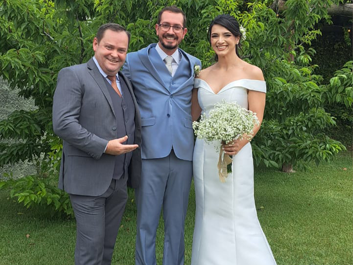 Celebrante de casamento Camilo Lelles com noivos em cerimônia no jardim