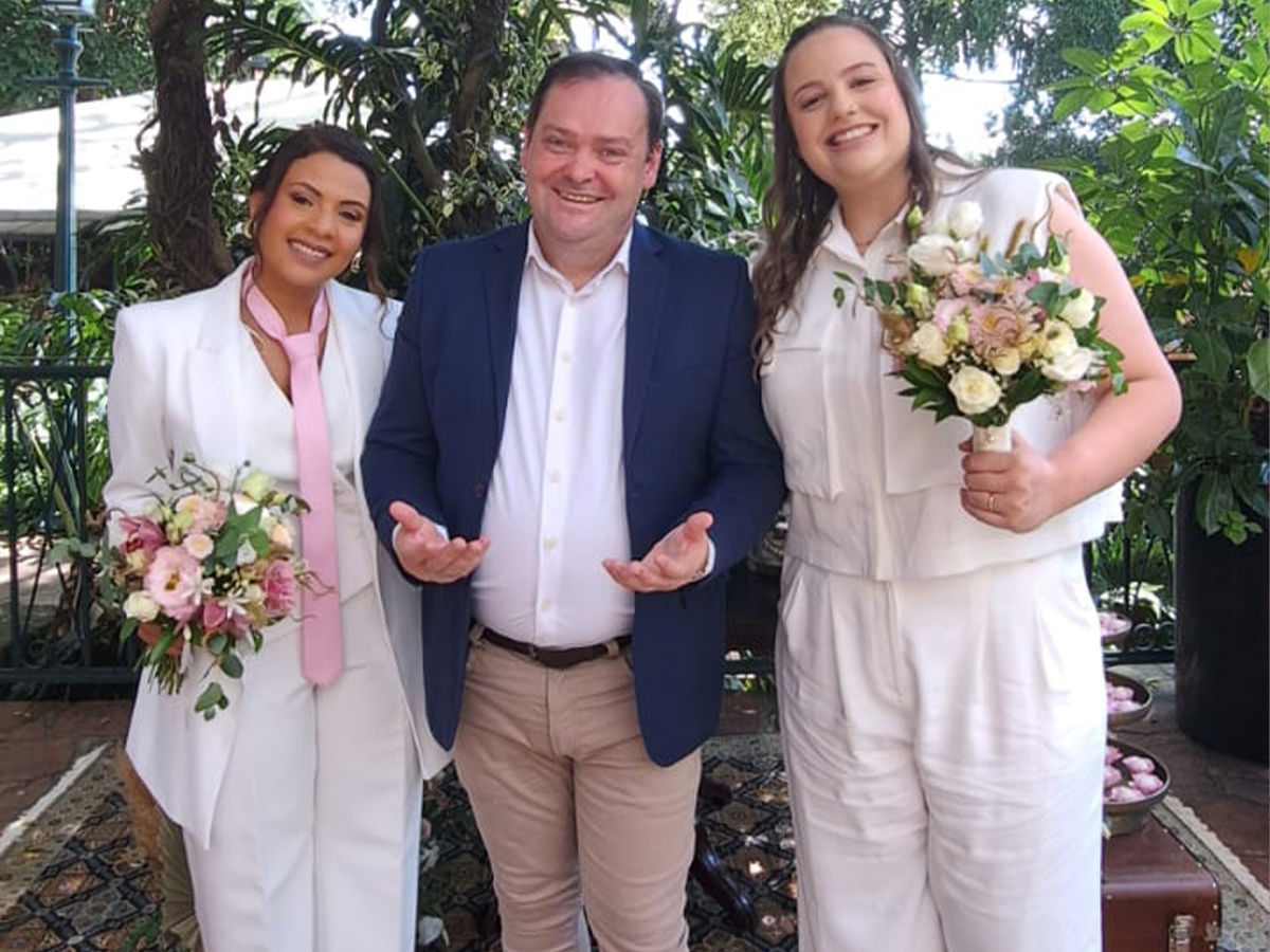 Camilo Lelles em cerimônia de casamento ao ar livre com duas noivas